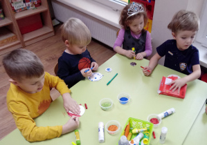 Dzieci wykonują kartkę świąteczną