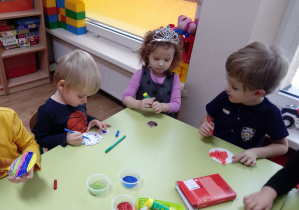 Dzieci wykonują kartę świąteczną