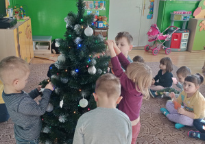 Dzieci ubierają choinkę