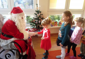 Mikołaj wręcza dzieciom cukierki