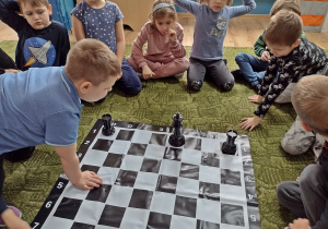 Chłopiec robi roszadę na szachownicy
