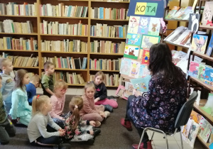 Dzieci słuchają utworu literackego o przygodach kotów