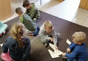 Dzieci składają z części ilustrację przedstawiającą koty