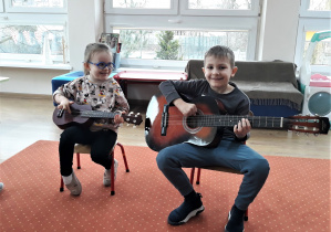 Chłopiec i dziewczynka grają na ukulele i gitarze