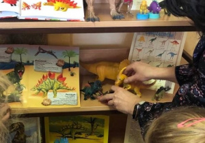 Dzieci oglądają figurki dinozaurów