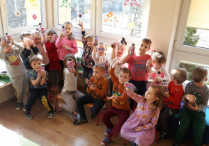 Dzieci pozują do zdjęcia z wykonanymi butelkami