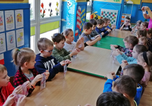 Dzieci umieszczają w woreczku z żelem kolorowy cekin- kropelka wody
