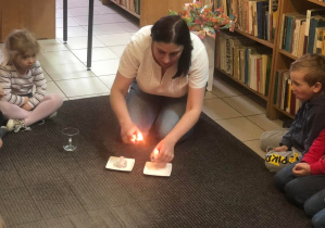 Nauczyciel podpala świeczki potrzebne do eksperymentu