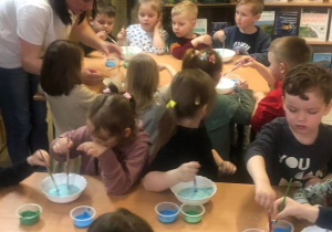 Dzieci zaczynają malować farbami na mleku kulę ziemską