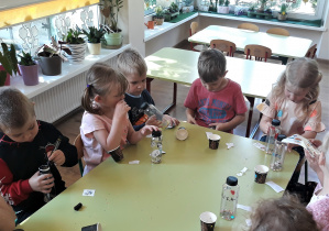 Dzieci wykonują grzechotki z butelek