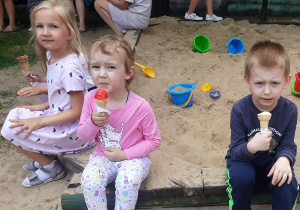 Dzieci jedzą lody w ogrodzie