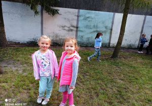 Dziewczynki stoją na placu zabaw.