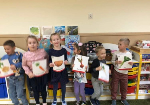 Dzieci prezentują zdjęcia owoców i warzyw.