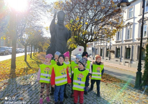 Dzieci stoją przed pomnikiem