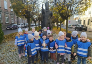 Dzieci stoją przy pomniku Papieża