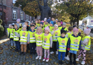 Przedszkolaki stoją przed pomnikiem Jana Pawła II
