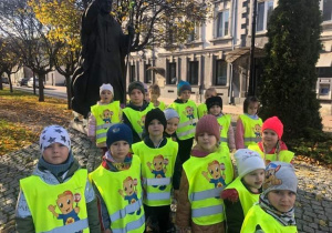 Dzieci stoją przed pomnikiem Jana Pawła II