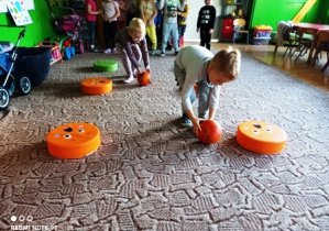 Dzieci toczą dynie slalomem