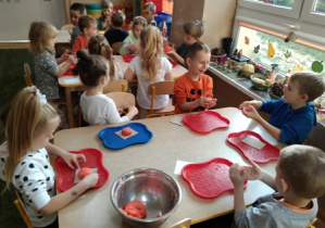 Dzieci badają właściwości masy solnej lepiąc dynię