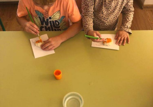 Dzieci malują dynie z masy solnej.