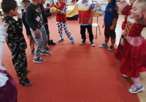 Dzieci w przebraniach tańczą w kole