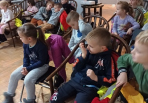Dzieci siedzą na krzesłach