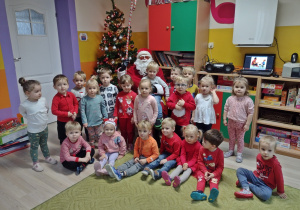 Dzieci pozują z Mikołajem do zdjęcia