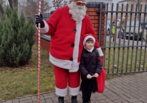 Mikołaj pozuje z dzieckiem do zdjęcia