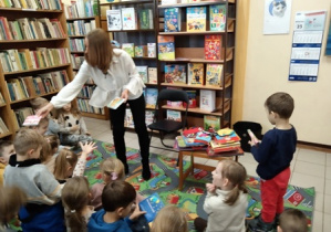 Pani bibliotekarka rozdaje przedszkolakom do ogldania rozmaitych książek