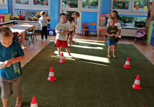 Dzieci ćwiczą slalom