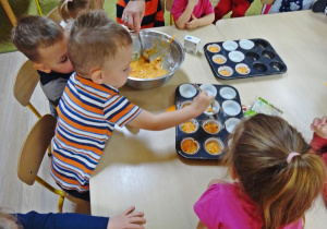 Dzieci nakładają ciasto