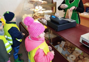 Dzieci oglądają jak pracuje sprzedawczyni