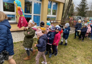 Dzieci stoją w parach przed przedszkolem