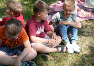 Dzieci siedzą na trawie w parku