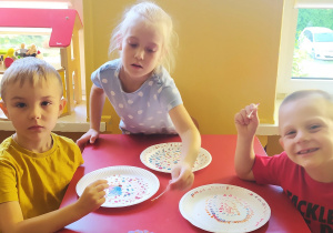 Dzieci wykonują "kropkową" pracę na talerzykach