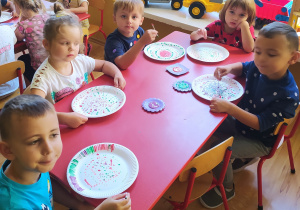 Dzieci malują kropki na papierowym talerzyku