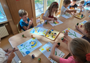 Dzieci wykonują pracę plastyczną z kropek - stemple z korka i farba plakatowa