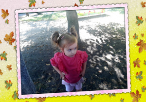 Dziewczynka stoi w ogrodzie przedszkolnym