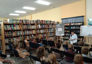 Przedszkolaki słuchają czytanego przez panią bibliotekarkę opowiadania z książeczki(1)