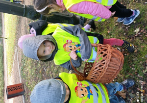 Dzieci zbierają kasztany i żołędzie do koszyka