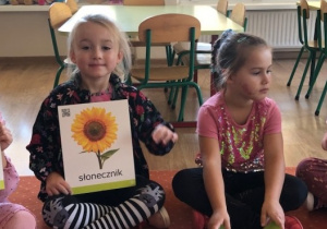 Dzieci prezentują ilustracje z kwiatami