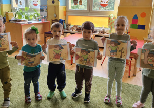 Dzieci pokazują ilustracje historyjki obrazkowej o drzewie