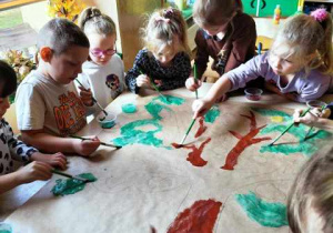 Dzieci wspólnie malują drzewo