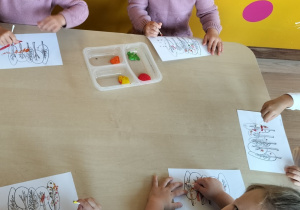 Dzieci wykonują pracę plastyczną farbami