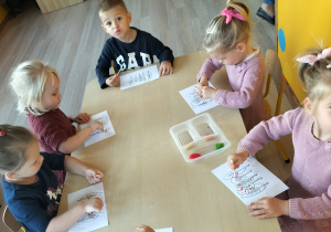 Dzieci wykonują pracę plastyczną farbami