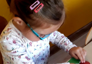 Dziewczynka wykonuje jeża z papieru