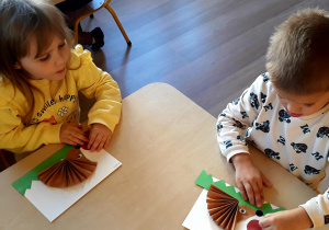 Dzieci wykonują pracę techniczną - jeża z papieru