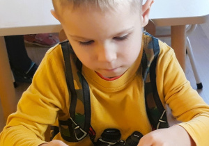 Chłopiec wykonuje jeża z papieru
