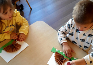 Dzieci wykonują pracę techniczną - jeża z papieru