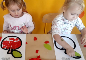 Dziewczynki wyklejają kontur jabłka bibułą